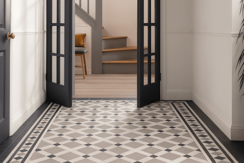 The victorian floor tiles feature a geometric pattern with light gray and black diamond shapes framed by dark border tiles