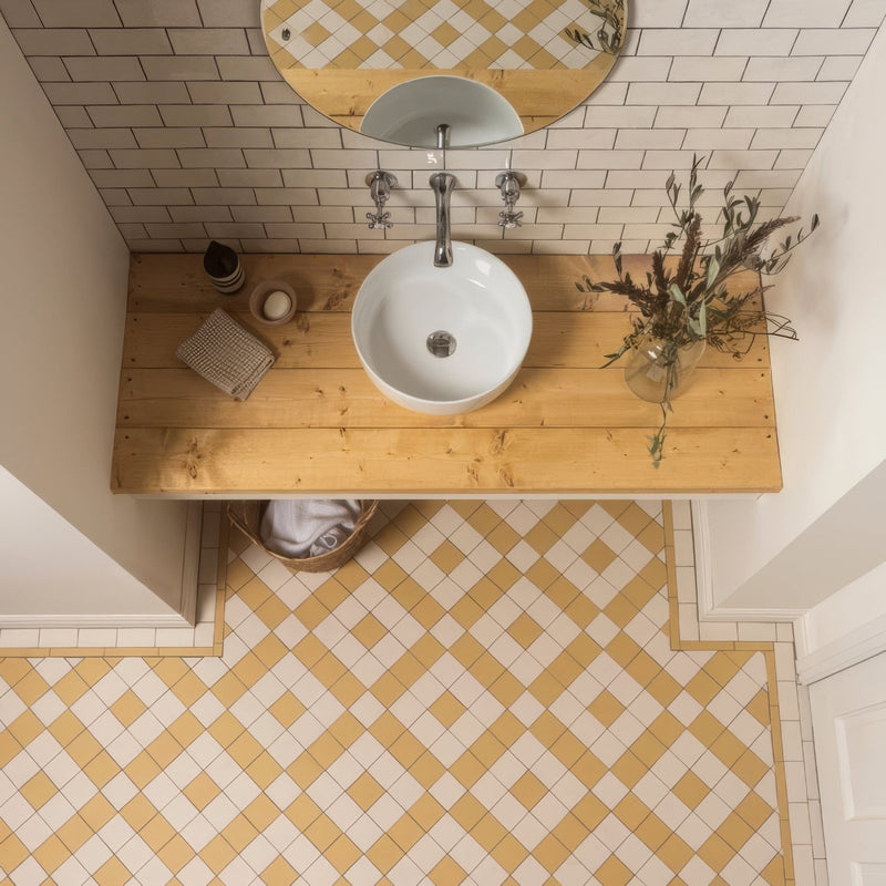 White ceramic bowl sink with sleek modern design mounted on light wood countertop in victorian floor tiles exeter pattern collection
