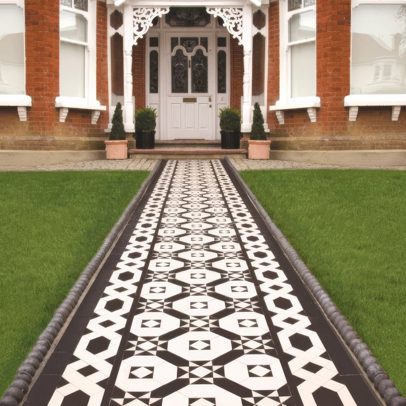 Black and white geometric patterned Victorian floor tiles in Westminster pattern used for tiled pathway flooring