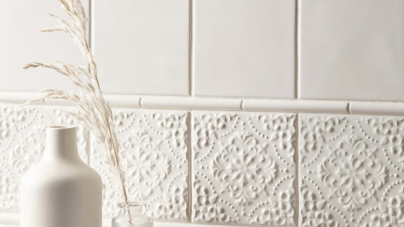 White ceramic wall tile with raised floral embossing in a collection titled white wall tiles