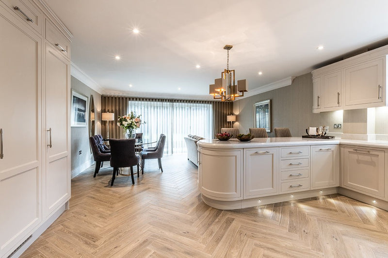 White kitchen island with curved edges and integrated drawers shown on wood effect floor tiles collection background