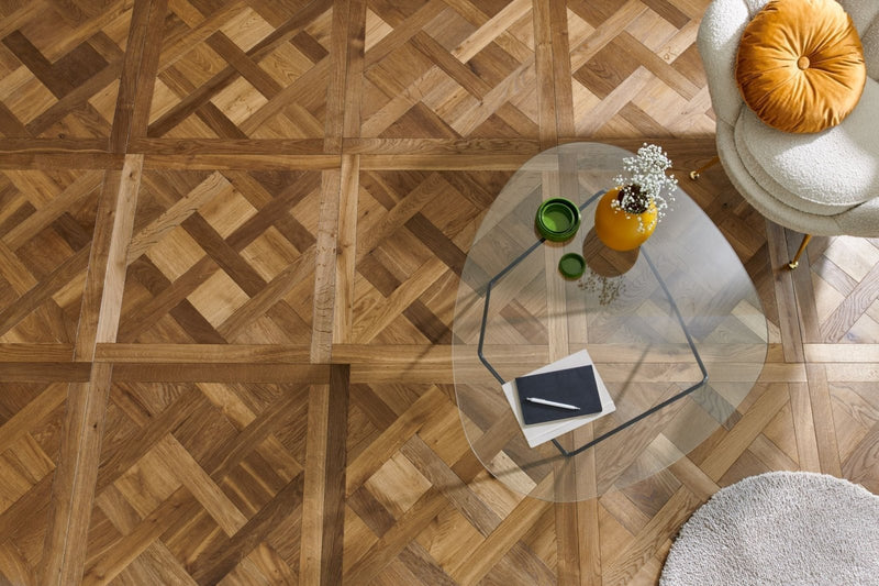 A modern glass-top coffee table with a black metal frame and geometric design from woodpecker design panels collection