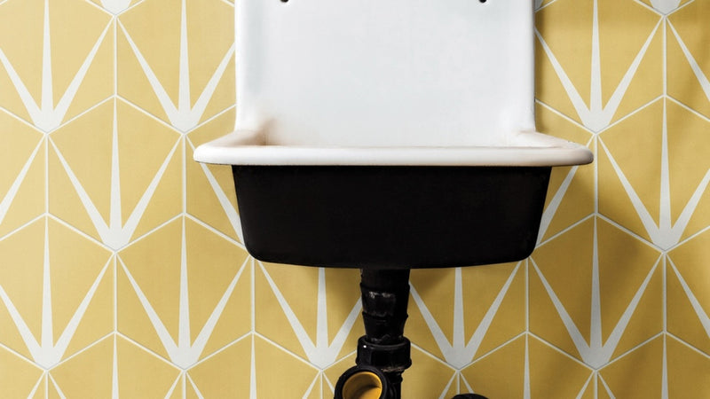 White and black enamel vintage sink featured with yellow wall tiles in a classic kitchen setting