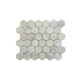 Carrara white honed marble hexagon mosaic tiles laid across a bathroom floor