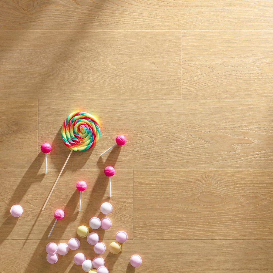 A vibrant rainbow-colored spiral lollipop with wooden stick on light wood-grain butter crisps f002 long vinyl planks