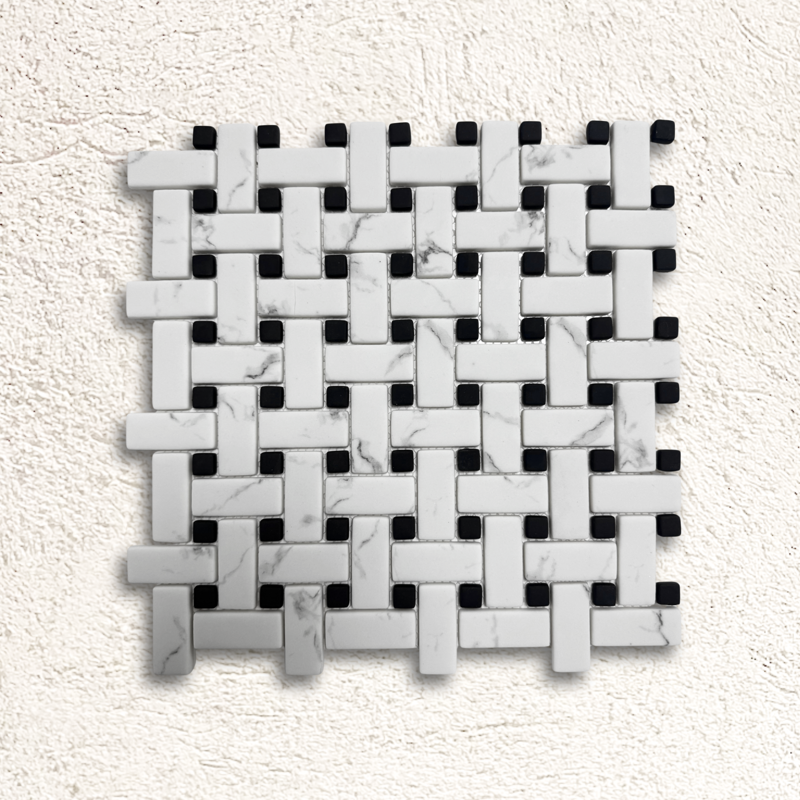 White marble and black mosaic tile in a woven basketweave pattern for ritz carrara mosaic design