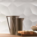 Two taupe matte ceramic pitchers with minimalist geometric handles on wood surface in 3d diamond white matt collection