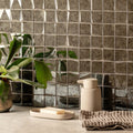 50mm Facet Mosaic Antique Mirror Grey grey antique mirror glass mosaic tiles with a faceted finish, shown alongside a soap dispenser