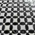Black and white marble flower mosaic laid as a bathroom floor with white sanitaryware