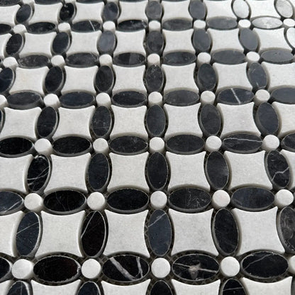 Black and white marble flower mosaic laid as a bathroom floor with white sanitaryware