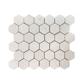Close detail of honed Shellstone limestone hexagon mosaic showing fossil markings in the warm beige stone