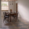 Ascoli Porcelain Grigio 40 x 40cm grey tiles used as flooring in a rustic dining room with a wooden table and black metal chairs