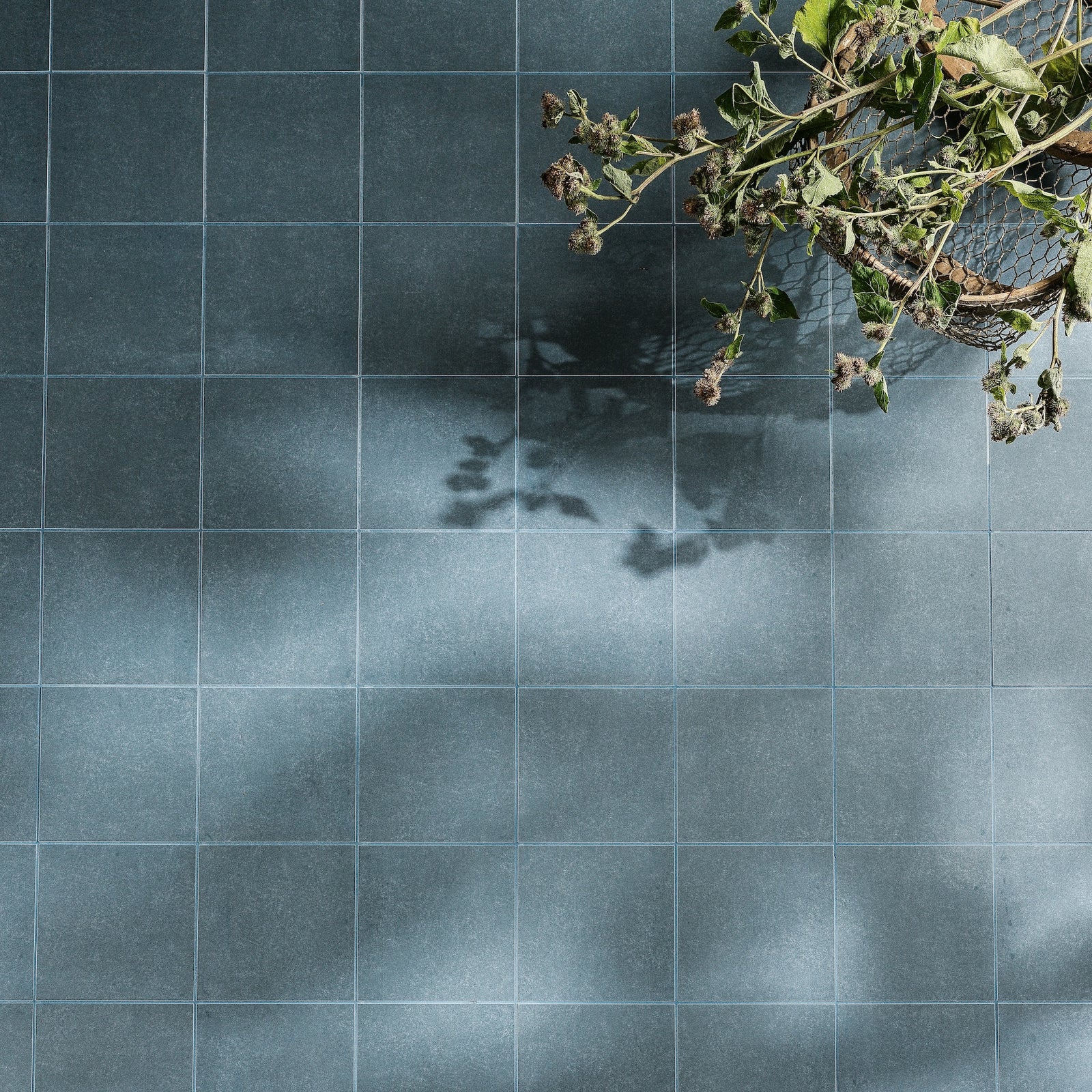Dark blue matte-finish ceramic floor tiles with subtle texture and light gray grout from adventuras navy field porcelain series