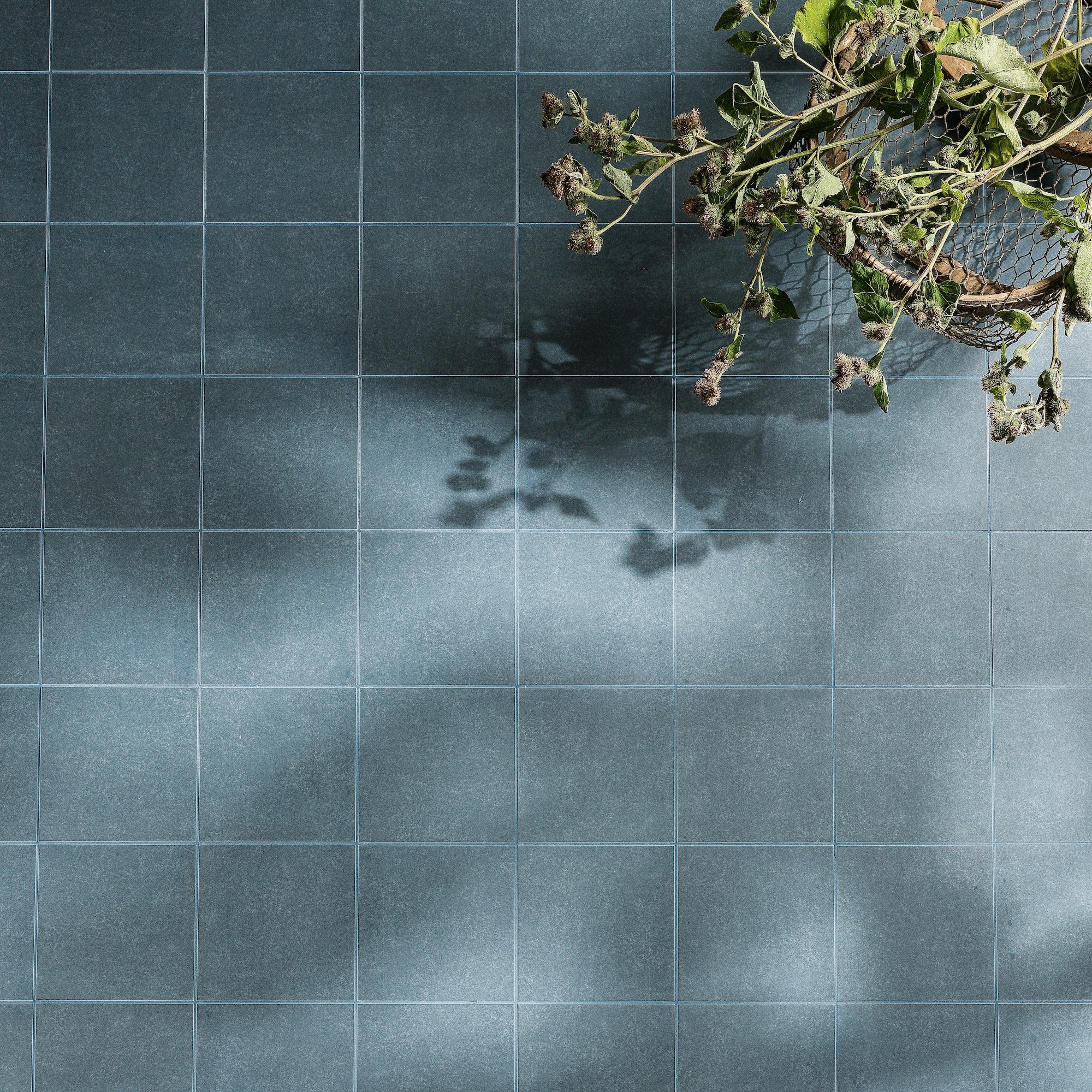 Dark blue matte-finish ceramic floor tiles with subtle texture and light gray grout from adventuras navy field porcelain series