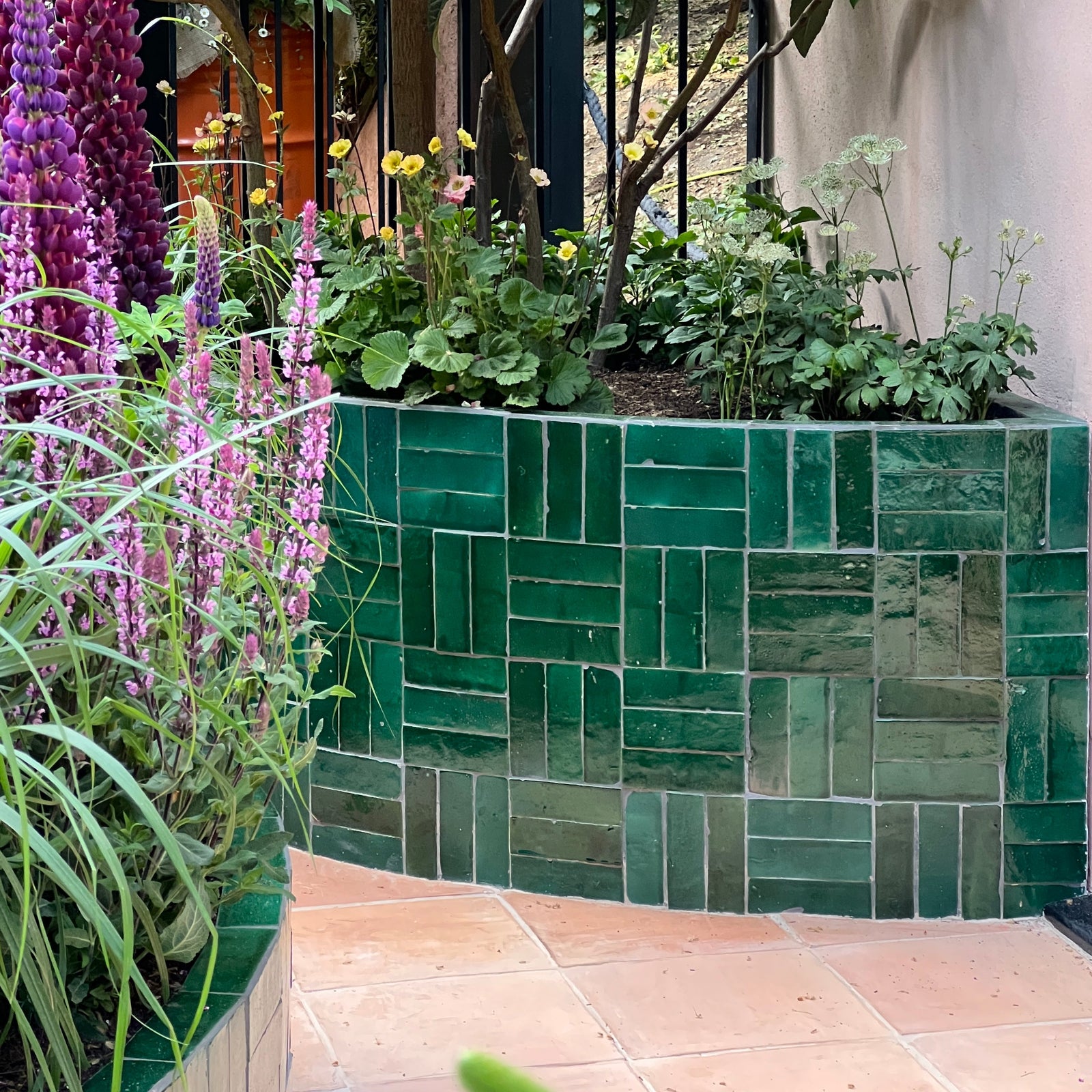 Medina moss green rectangle handmade moroccan zellige tile in emerald green glazed ceramic arranged in herringbone pattern on planter edge