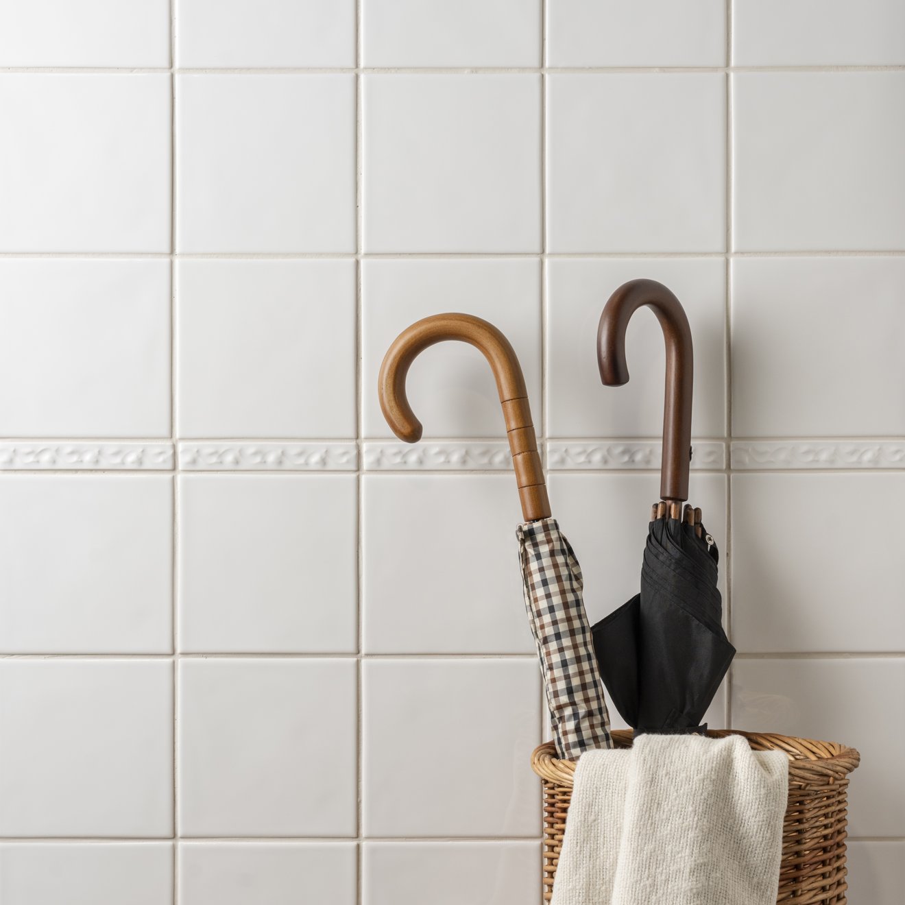Beaulieu moulding helmingham two closed umbrellas with wooden handles in checkered and black patterns in wicker basket