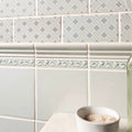 Beaulieu moulding Sudbury featuring gray subway tiles with subtle snowflake pattern and ornate white decorative border