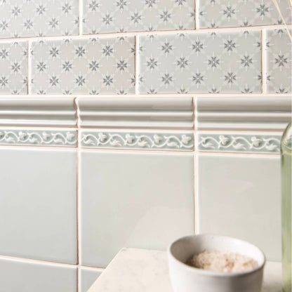 Beaulieu moulding Sudbury featuring gray subway tiles with subtle snowflake pattern and ornate white decorative border