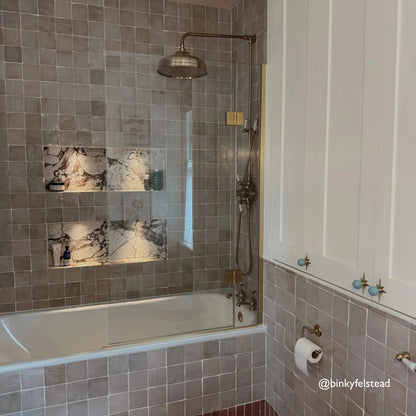 Bathroom with tiled walls, a bathtub, and shower fixtures.