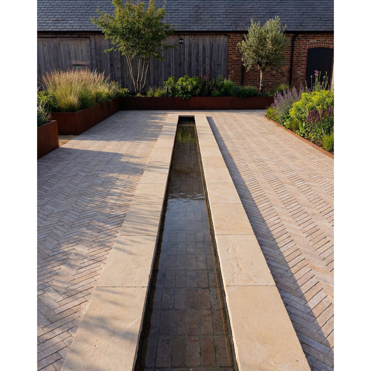 Buscot Limestone Tumbled & Etched Cropped Coping edging a terrace