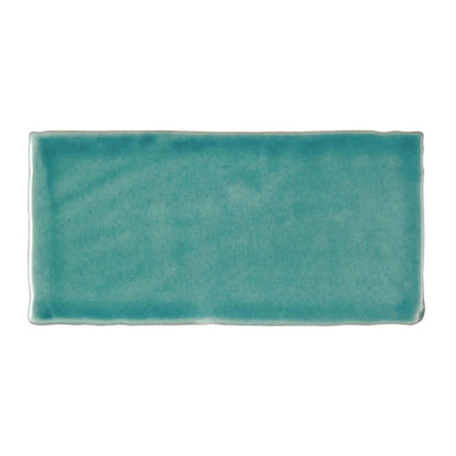 A rectangular ceramic Carnival Laredo blue glazed tile with matte turquoise finish and handcrafted edges