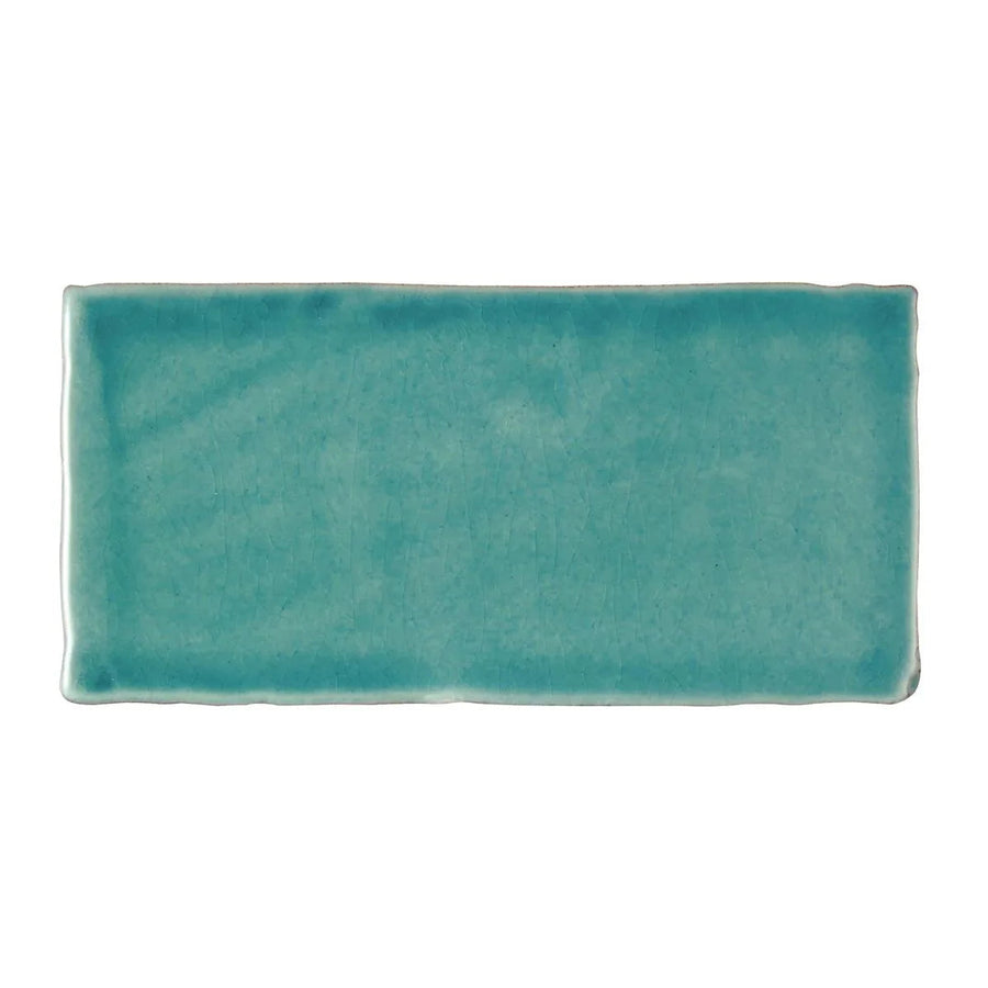 A rectangular ceramic Carnival Laredo blue glazed tile with matte turquoise finish and handcrafted edges