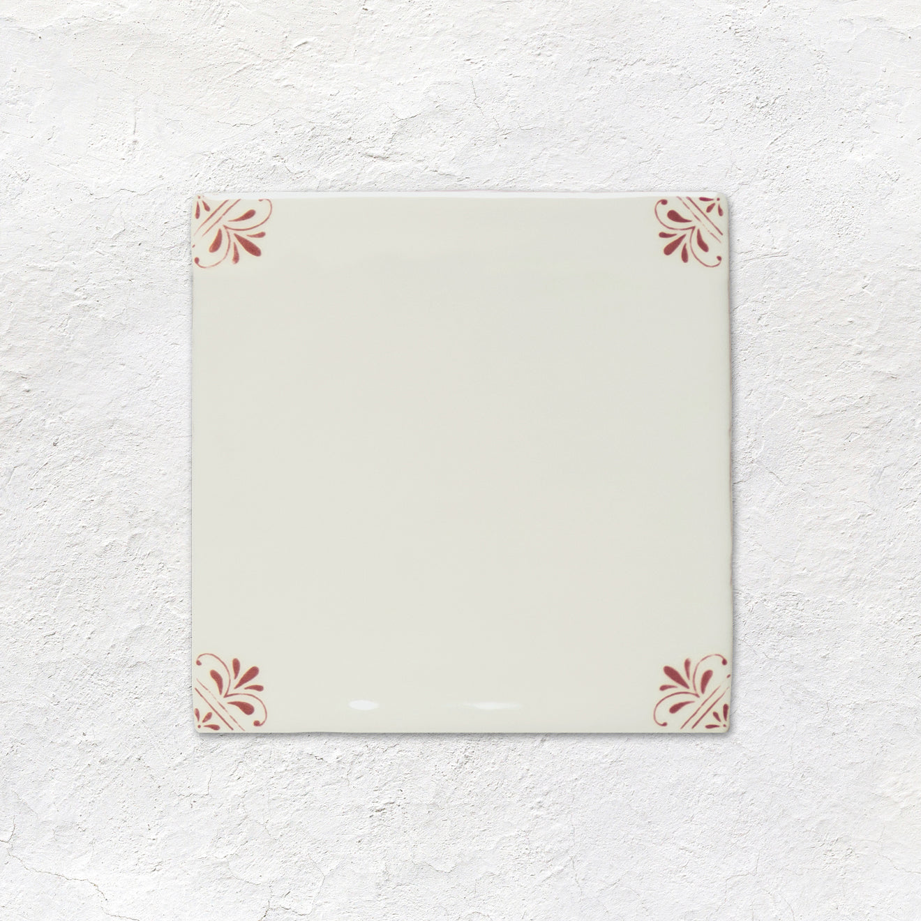 Rectangular ceramic tile with decorative patterns on a textured white background