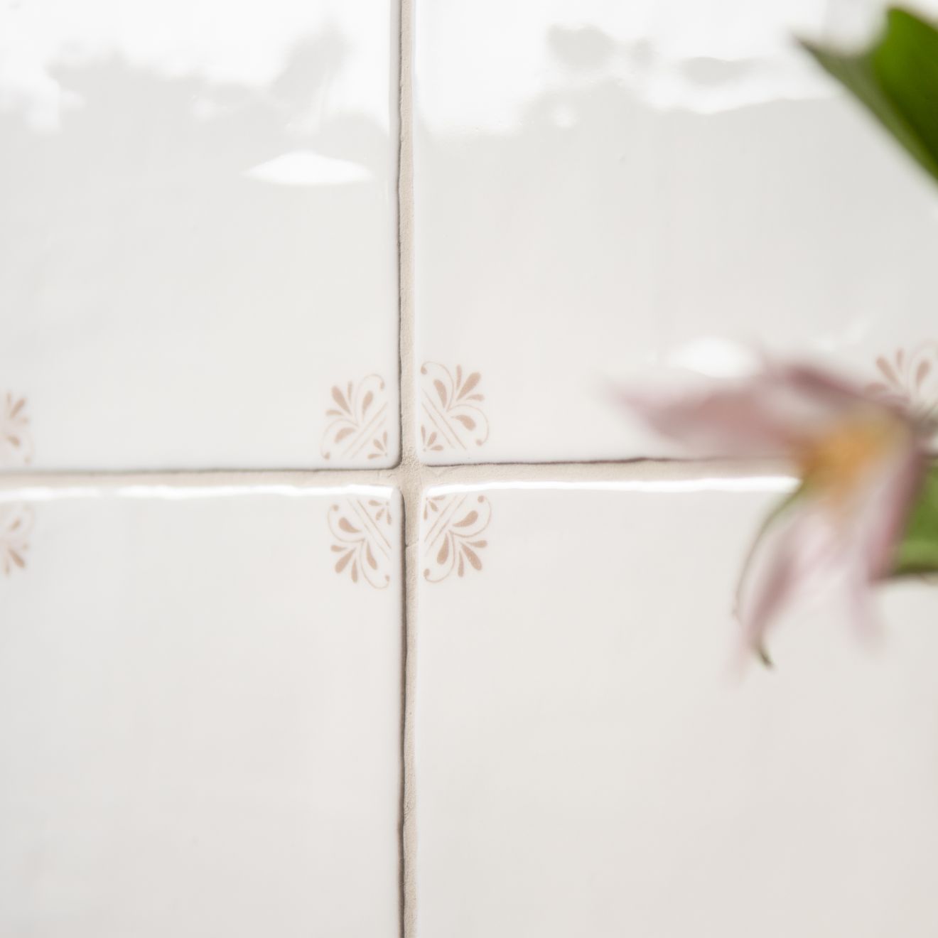 Close-up of white tiles with floral patterns on a blurred background