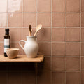 Cream-colored ceramic pitcher with vertical ridges and handle holding wooden spoons field tile birch design