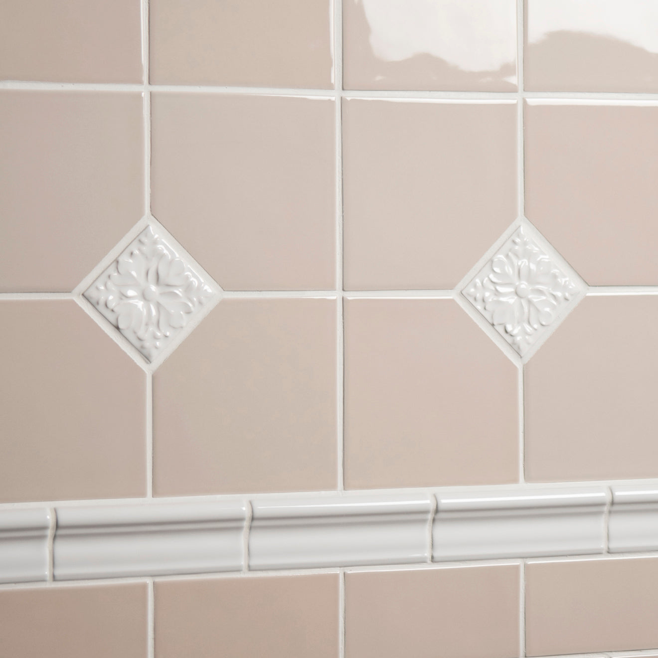 Close-up of beige tiles with decorative white border