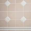 Close-up of beige tiles with decorative white accents