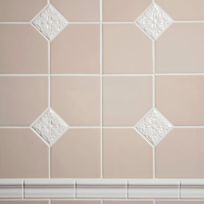 Close-up of beige tiles with decorative white accents