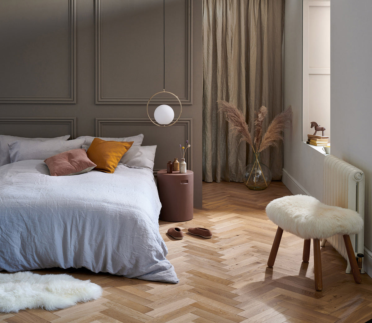 Woodpecker oak herringbone flooring in a panelled bedroom
