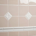 Close-up of beige tiles with decorative white border