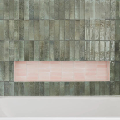 A rectangular pink ceramic tile tray displayed against textured gray green vertical tiles for decor use