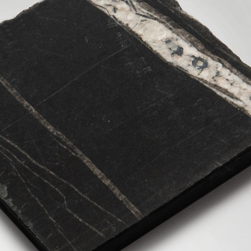 Black tumbled marble square tiles used as a kitchen splashback