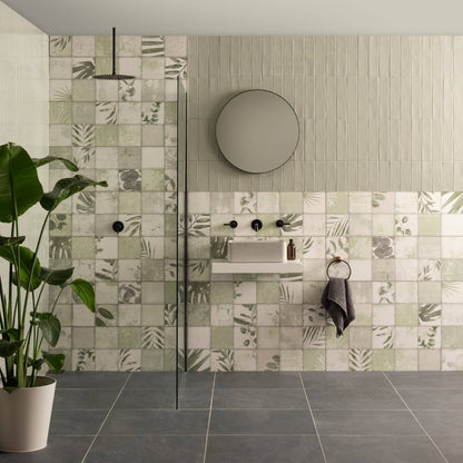 Large brick tile tern with modern patchwork wall design in muted green beige and gray tones featuring subtle dark green leaf patterns