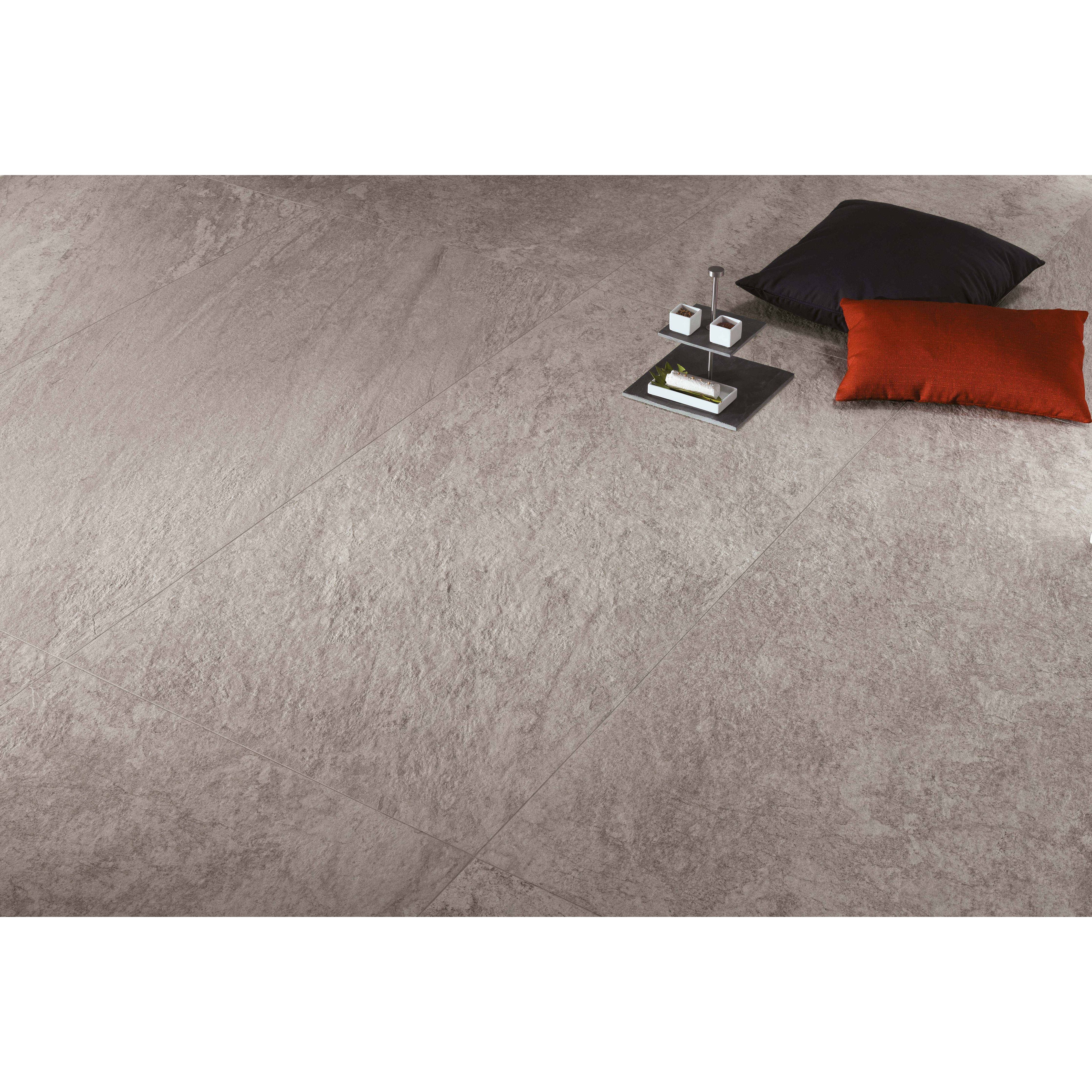 Gray textured floor with decorative pillows and a small table.