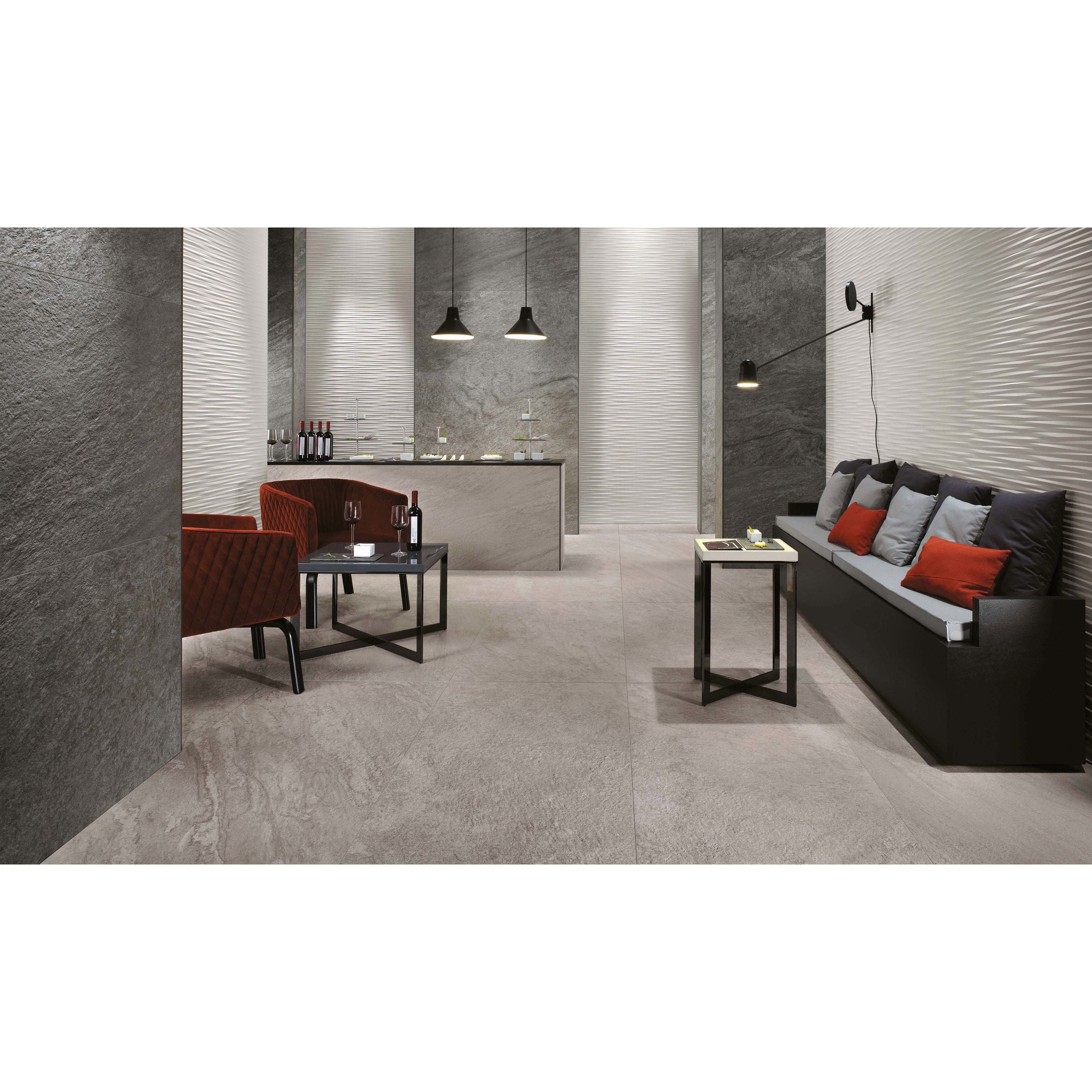 Modern interior with gray tiles, a sofa, and red cushions.