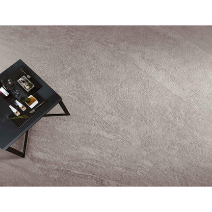 Gray tiled floor with a small black table and decorative items.