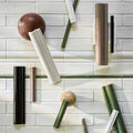 Decorative wall art with cylindrical and spherical objects on a tiled wall background