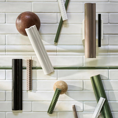 Decorative wall art with cylindrical and spherical objects on a tiled wall background