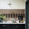 Modern kitchen with black cabinets, white countertop, and decorative tile backsplash.