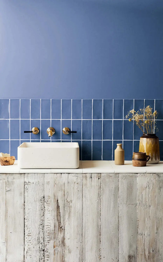 Our Navy Glazed metro tiles create the perfect backsplash in this beautiful small bathroom featuring a basin by Kast Concrete Basins, and fixtures by Samuel Heath (pots are from Retro Vintage Leeds). Metro tiles instantly add to this wall space with a painted wall above in the same colour