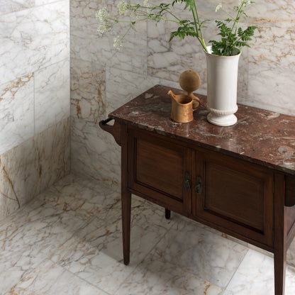 Ottoman Marble Honed white marble tiles with a dark wood side table