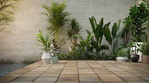 Beige stone outdoor flooring tiles with embedded recessed lights and bordering greenery on a stone pathway.