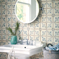 A round chrome finished wall mounted mirror with a sleek minimalist design displayed with paris isabelle patterned terracotta tile