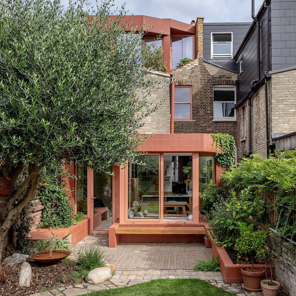 Quarry red square tile used on a modern extension with terracotta-colored tiled walls and large glass windows