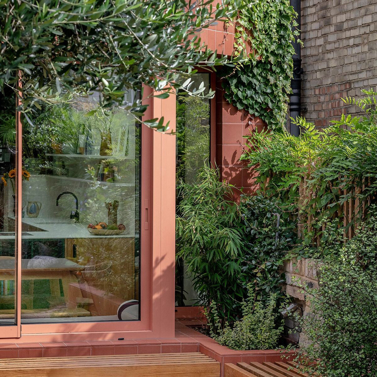 A sleek peach-colored sliding glass door with a modern frame and clean lines for quarry red square tile settings