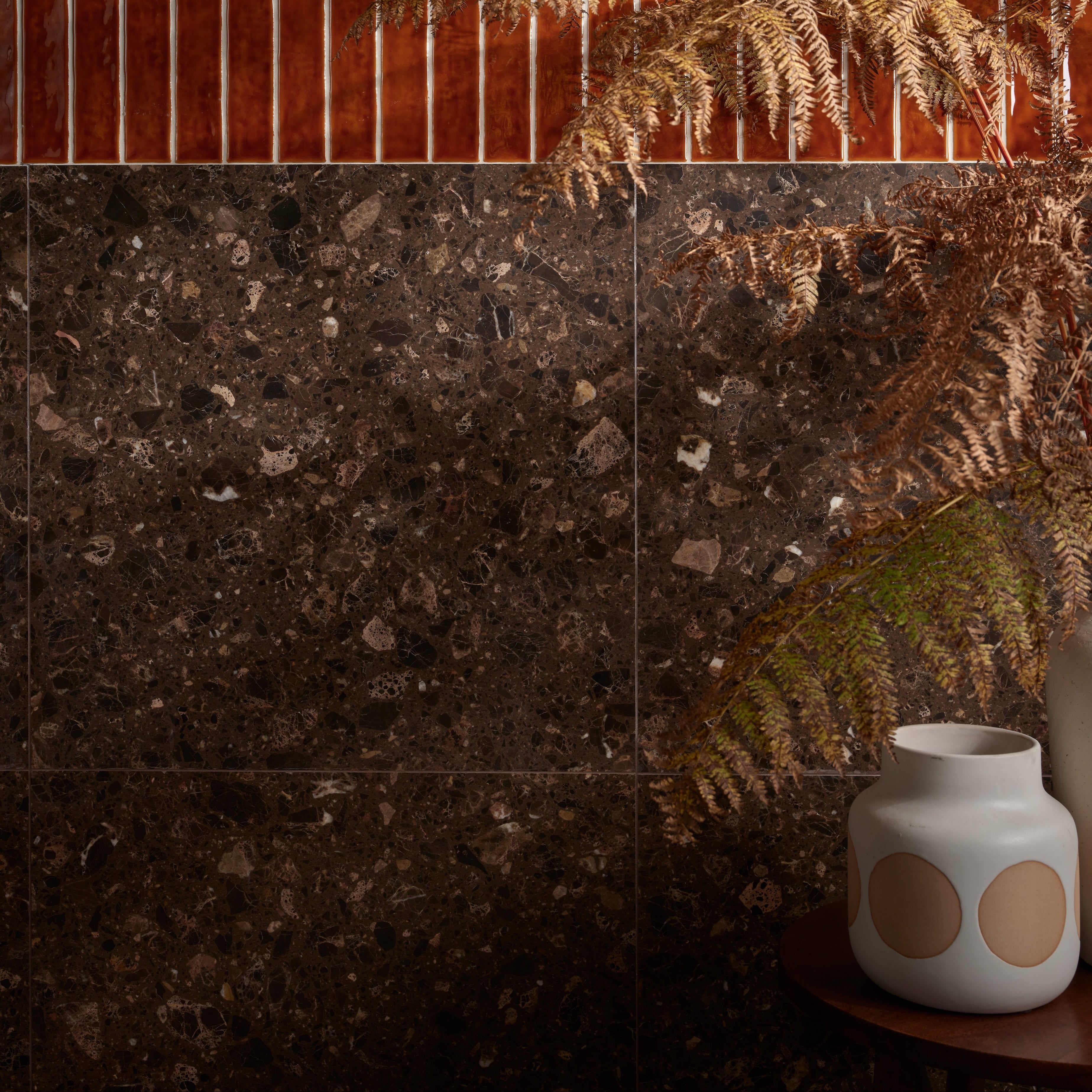 Rialto Terrazzo Ca'Doro Honed dark brown terrazzo tiles with a white ceramic vase